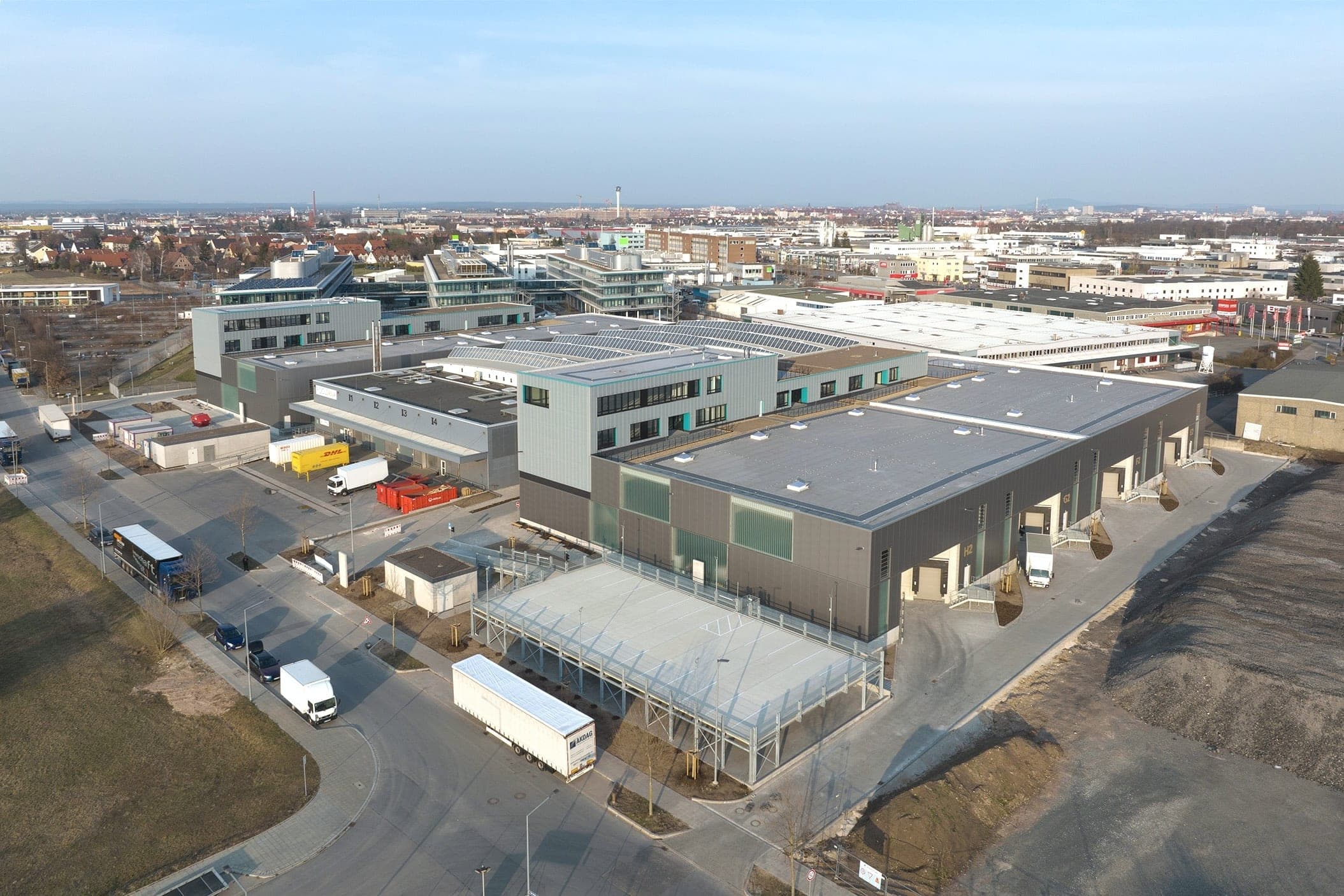 Light Industrial Gewerbepark für BEOS in Nürnberg, Luftbild der Hallen mit türkis akzentuiertem Büroriegel