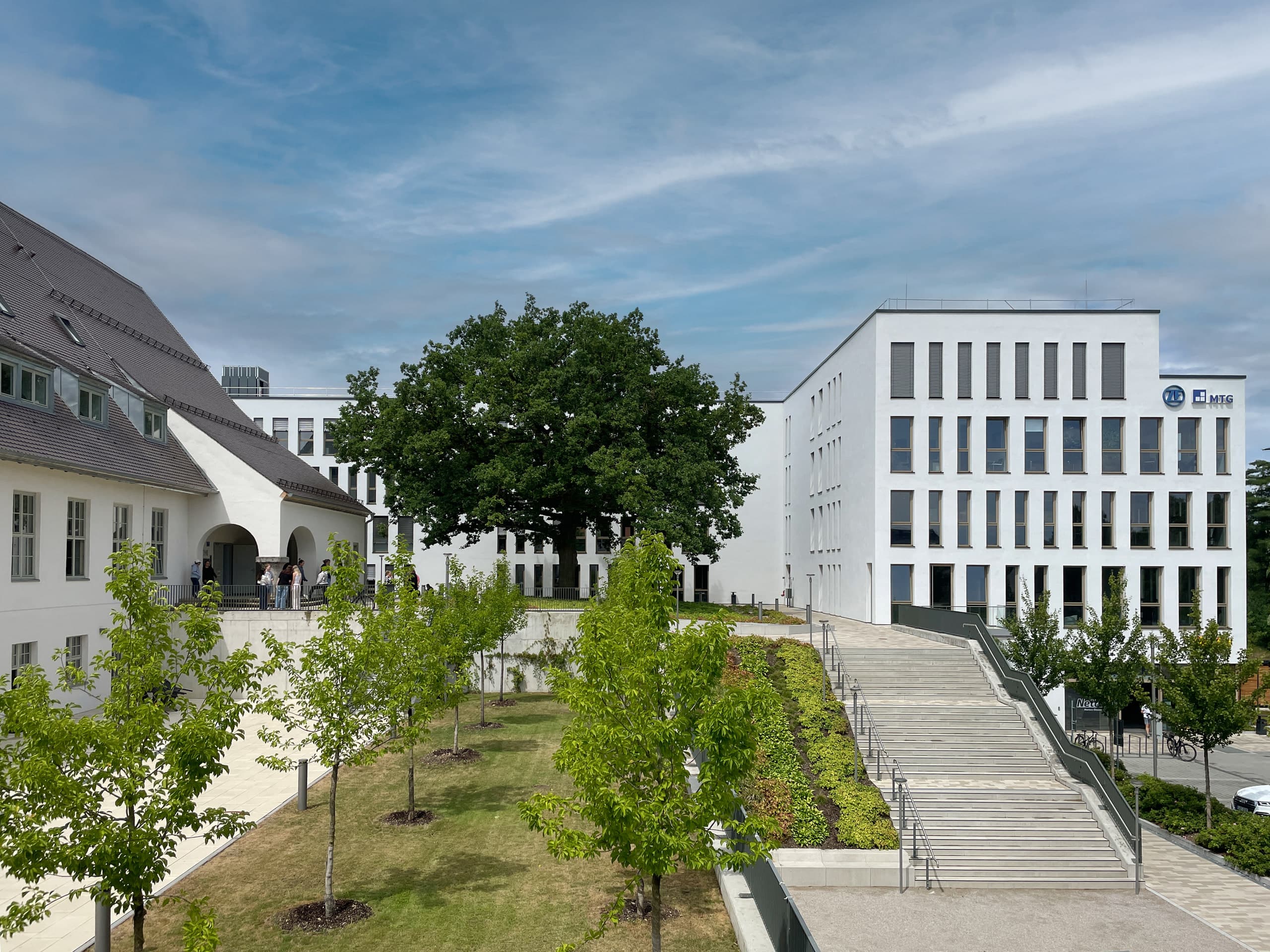 Visualisierung des sanierten Altbaus mit neuem Bürotrakt und begrüntem Dach im Grünareal.
